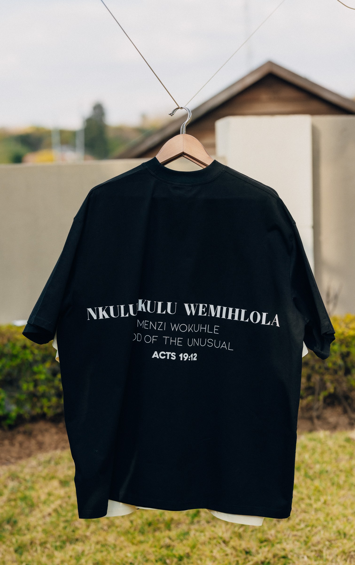 A black statement T-shirt hanging outdoors