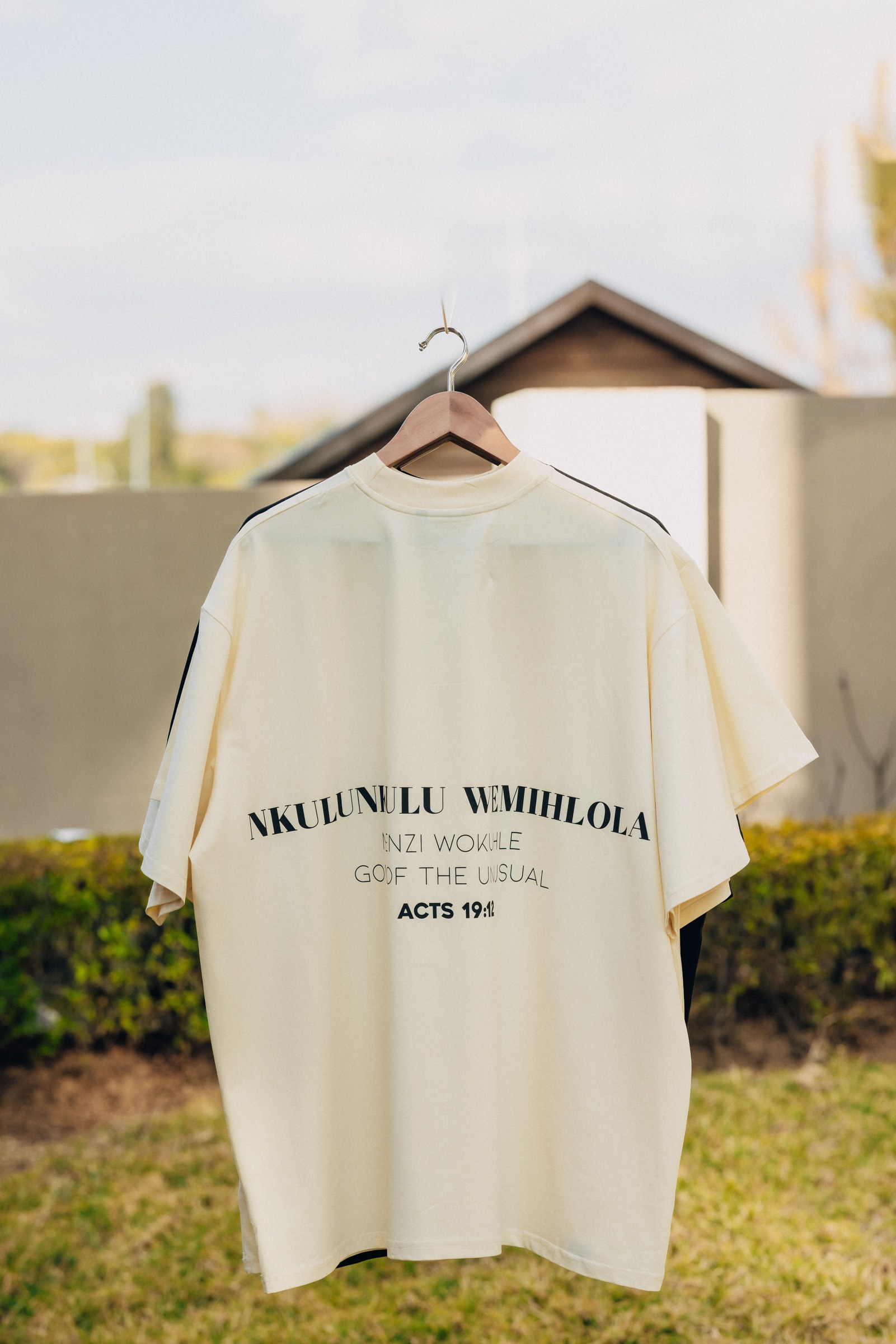 A white statement T-shirt hanging outdoors