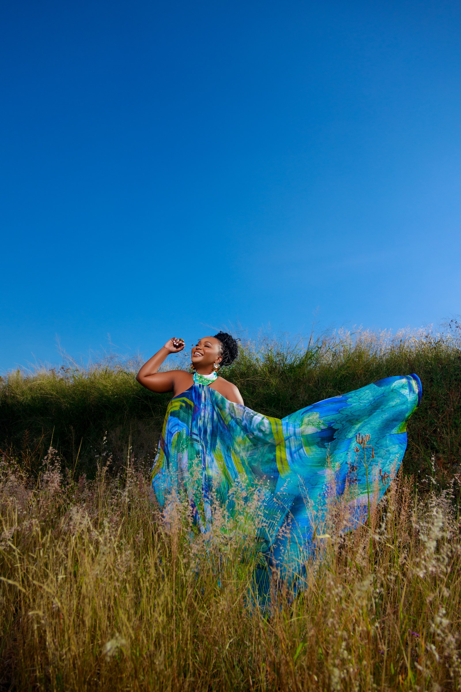 Xolly extending her dress among tall grasses