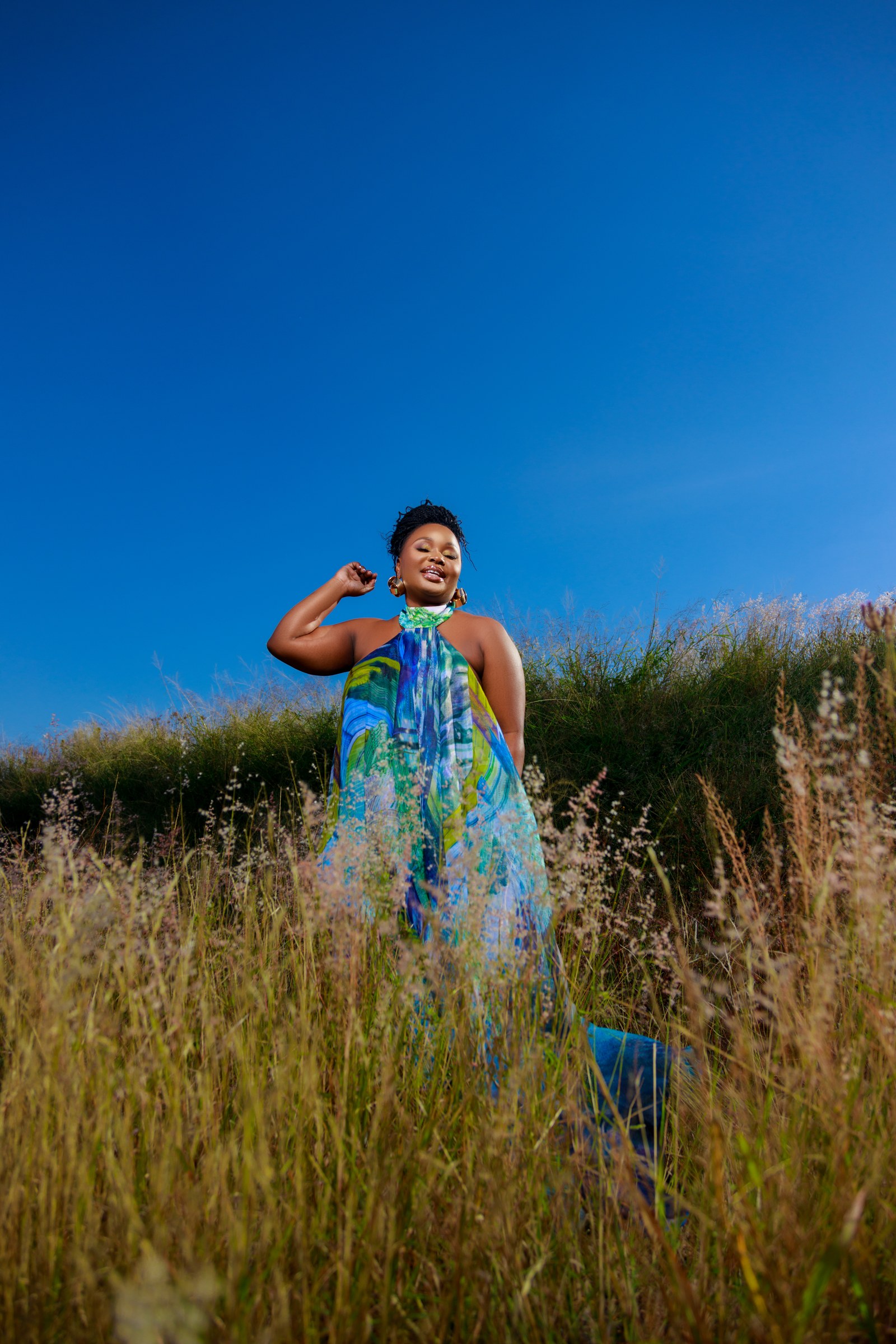 Xolly in a flowing patterned dress in a field
