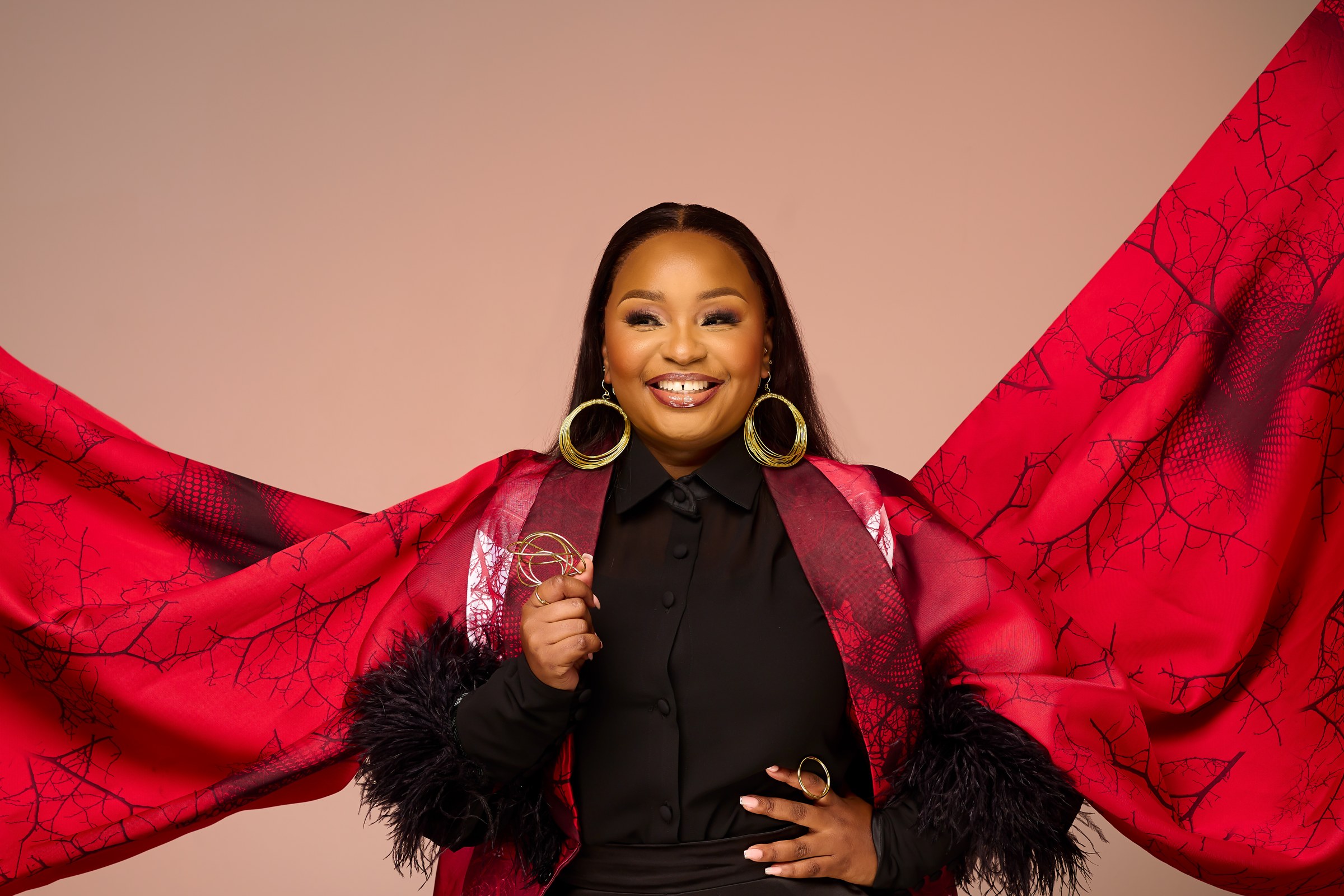 Xolly smiling in a black ensemble with red fabric
