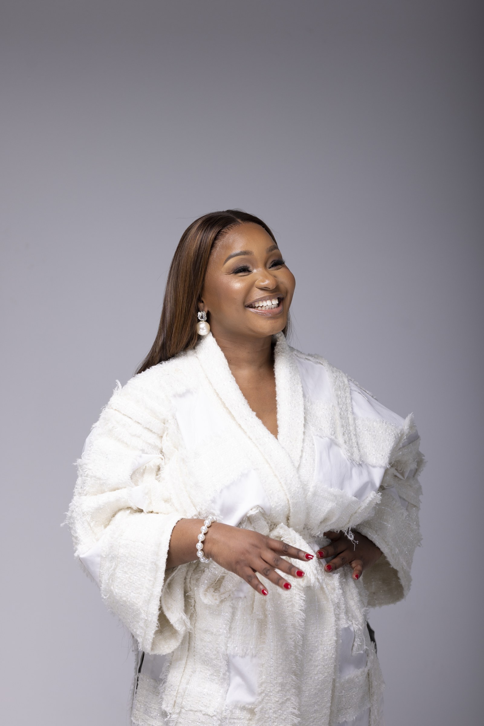 Xolly smiling in a white couture ensemble