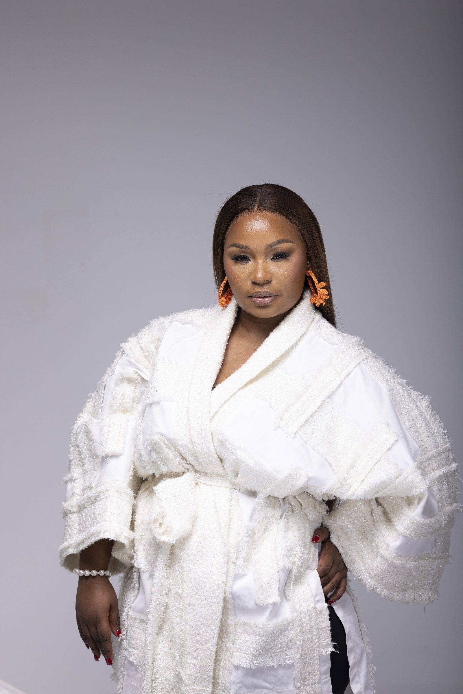 Xolly wearing a white belted couture ensemble